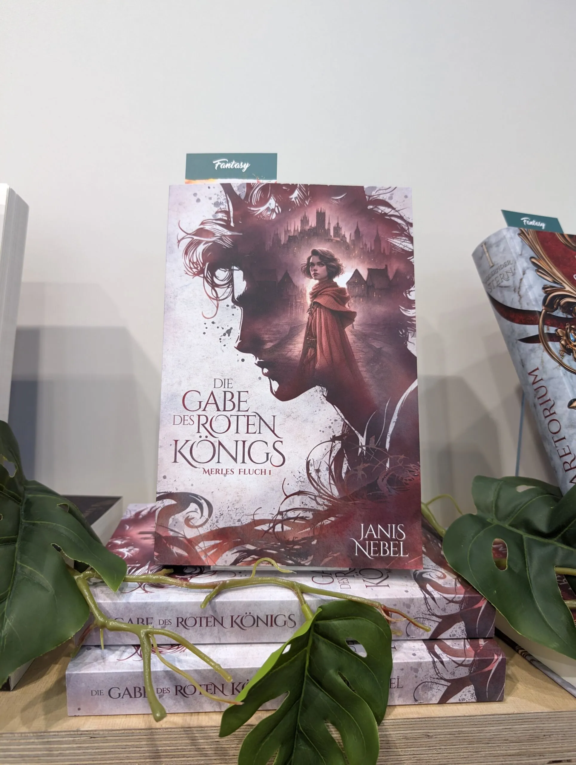 Zu sehen ist das Buch "Die Gabe des roten Königs" von Janis Nebel auf dem Messestand von tolino media bei der Leipziger Buchmesse 2024